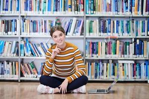 el estudiante usa un cuaderno y una biblioteca escolar foto