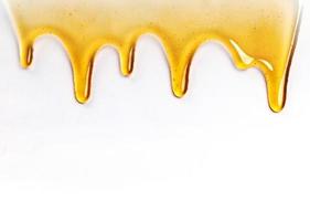 Dripping honey seamlessly repeatable from the top over white with copyspace and text photo