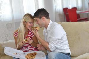 pareja en casa comiendo pizza foto