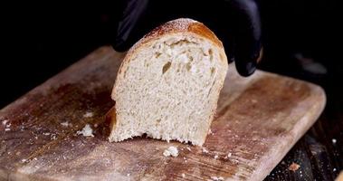 cortar en trozos pan de centeno fresco durante la cocción foto