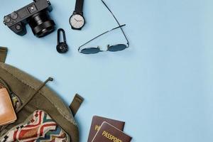 Top view mockup of Traveler's accessories with passport, wallet, camera, hat and backpack isolated colorful blue background with empty space, Tropical travel concept photo