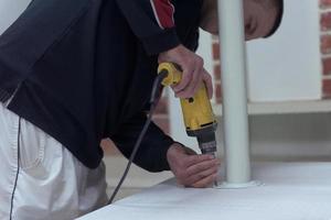 repairman working with drilling machine photo