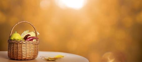 Autumn banner with still life composition made from basket and vegetables, autumn fall leaf on background with sunlight and bokeh. Copy space photo