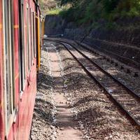 Toy Train moving on mountain slopes, beautiful view, one side mountain, one side valley moving on railway to the hill, among green natural forest. Toy train from Kalka to Shimla in India, Indian Train photo