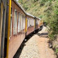 tren de juguete moviéndose en las laderas de las montañas, hermosa vista, una montaña lateral, un valle lateral moviéndose en ferrocarril hacia la colina, entre bosques naturales verdes. tren de juguete de kalka a shimla en india, tren indio foto