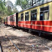 Toy Train moving on mountain slopes, beautiful view, one side mountain, one side valley moving on railway to the hill, among green natural forest. Toy train from Kalka to Shimla in India, Indian Train photo