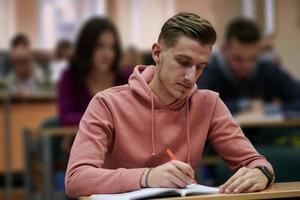 estudiante tomando notas mientras estudia en la escuela secundaria foto