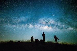 Blue dark  night sky with with star Milky way Space background and silhouette of a standing happy man photo