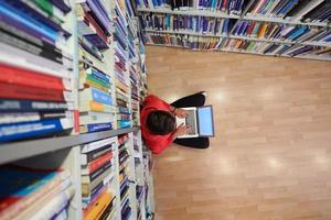 los estudiantes usan un cuaderno, una computadora portátil y una biblioteca escolar foto