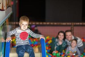 parents and kids playing in the pool with colorful balls photo