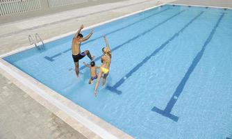 happy young family have fun on swimming pool photo