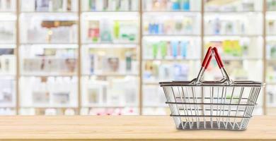 Empty shopping basket on pharmacy drugstore counter with blur shelves of medicine and vitamin supplements background photo