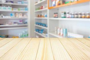 mostrador de farmacia con fondo abstracto borroso con medicamentos y productos sanitarios en los estantes foto