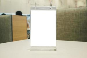 Mockup empty white label menu frame on table with cafe restaurant interior background photo