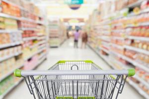 Supermarket aisle with empty shopping cart at grocery store retail business concept photo