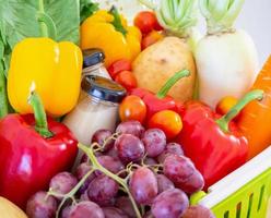 Fresh fruits and vegetables in green shopping basket photo