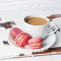 Cup of coffee and macaroon cookies on a plate on a white background. copy space photo