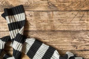 Striped wool scarf on brown wood background. Copy space photo