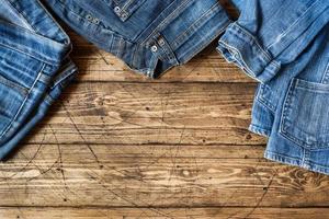 Jeans clothes and accessories on brown wood background photo