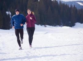 pareja trotando afuera en la nieve foto