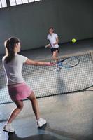 young girls playing tennis game indoor photo