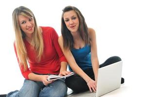 dos chicas jóvenes trabajan en una laptop aislada foto