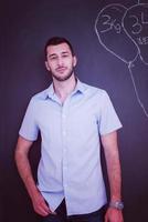 portrait of man in front of black chalkboard photo