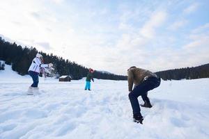 familia feliz jugando juntos en la nieve en invierno foto