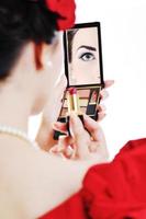 beautiful young woman applying makeup photo