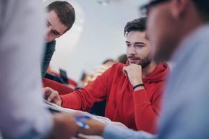 grupo de estudiantes trabajando juntos en un proyecto escolar en una tableta en una universidad moderna foto