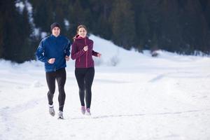 pareja trotando afuera en la nieve foto