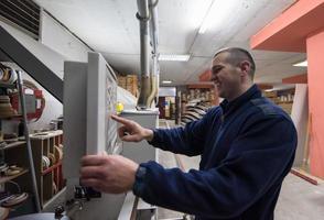 carpintero calculando y programando una máquina de trabajo de madera cnc foto