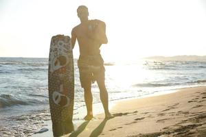 retrato, de, un, joven, kitsurf, hombre, en, playa, en, ocaso foto