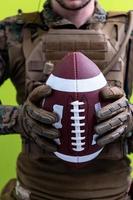 solder holding american football ball photo