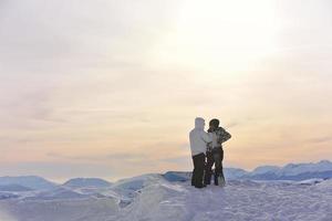 pareja de snowboarders en la cima de la montaña foto