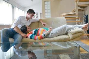 pregnant couple at home using tablet computer photo