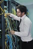 young it engineer in datacenter server room photo