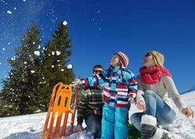 family having fun on fresh snow at winter photo