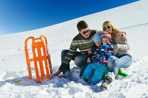 familia divirtiéndose en la nieve fresca en las vacaciones de invierno foto