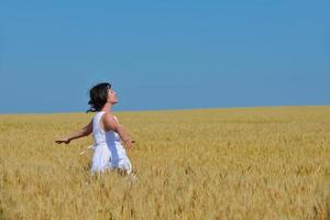 mujer joven en campo de trigo en verano foto