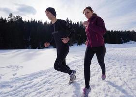 pareja trotando afuera en la nieve foto