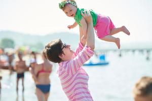 mamá y bebé en la playa se divierten foto