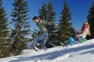 family having fun on fresh snow at winter vacation photo