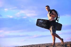 Portrait of a young  kitsurf  man at beach on sunset photo