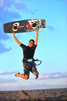 retrato, de, un, joven, kitsurf, hombre, en, playa, en, ocaso foto