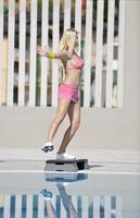 ejercicio de fitness de mujer junto a la piscina foto