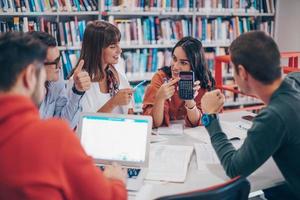 grupo de estudiantes trabajando juntos en un proyecto escolar en una tableta en una universidad moderna foto