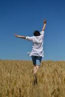 mujer joven en campo de trigo en verano foto