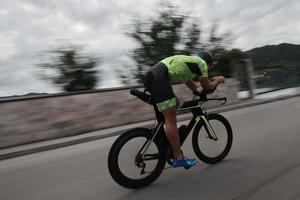 atleta de triatlón montando en bicicleta en el entrenamiento matutino foto