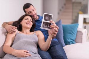 pareja embarazada mirando el ultrasonido del bebé foto